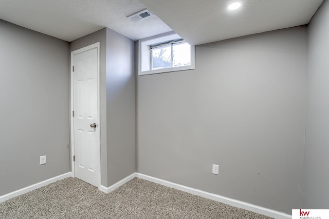 basement with carpet and a textured ceiling