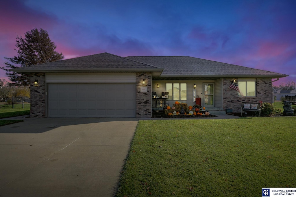 ranch-style home with a yard and a garage