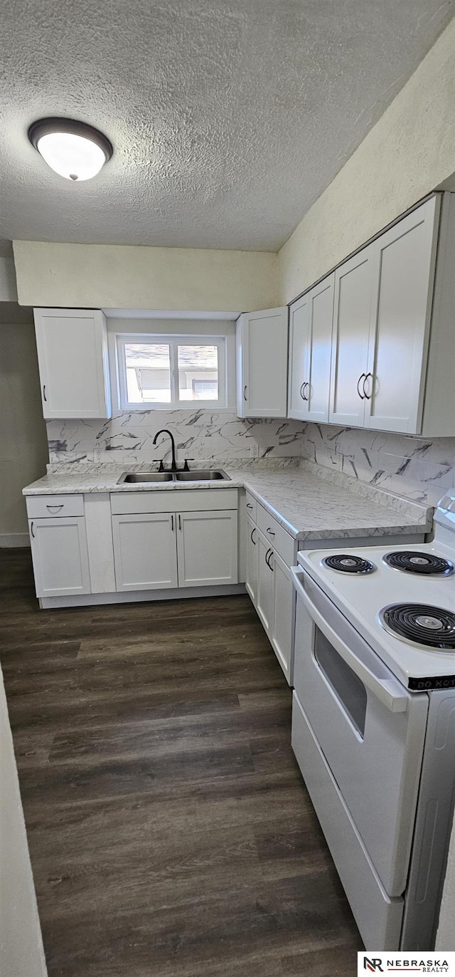 kitchen with white range with electric cooktop, white cabinets, and sink