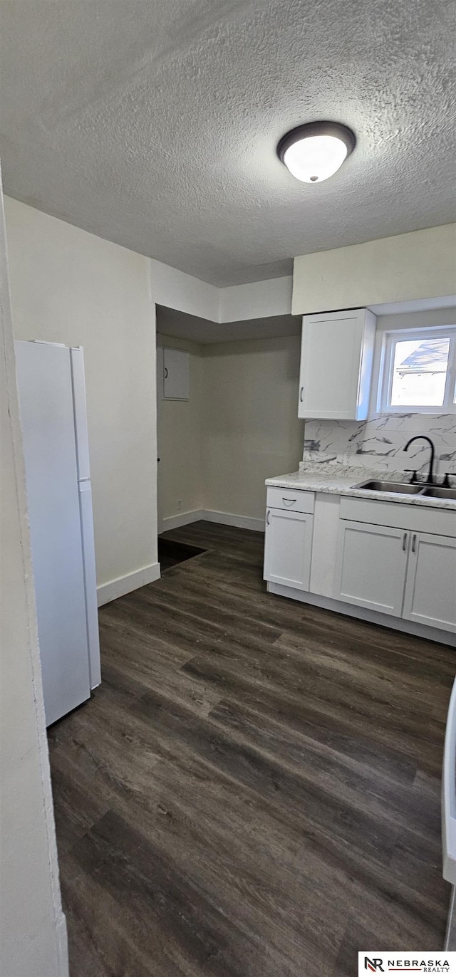 kitchen featuring white cabinets, white refrigerator, sink, decorative backsplash, and dark hardwood / wood-style flooring