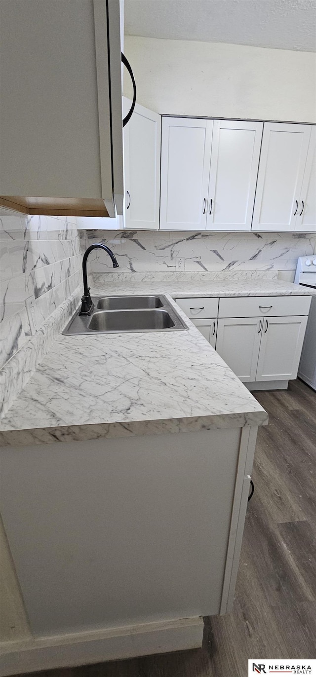 kitchen with white cabinets, decorative backsplash, dark hardwood / wood-style floors, and sink