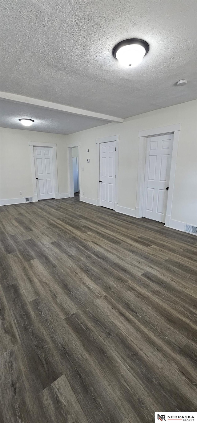 unfurnished room featuring dark hardwood / wood-style floors and a textured ceiling