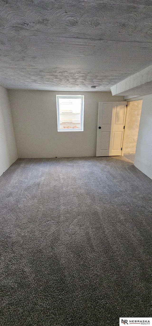 carpeted spare room featuring a textured ceiling