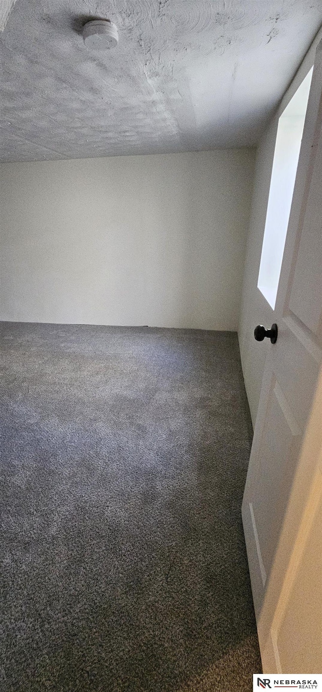 carpeted spare room featuring a textured ceiling