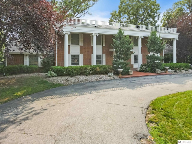 greek revival inspired property with a balcony