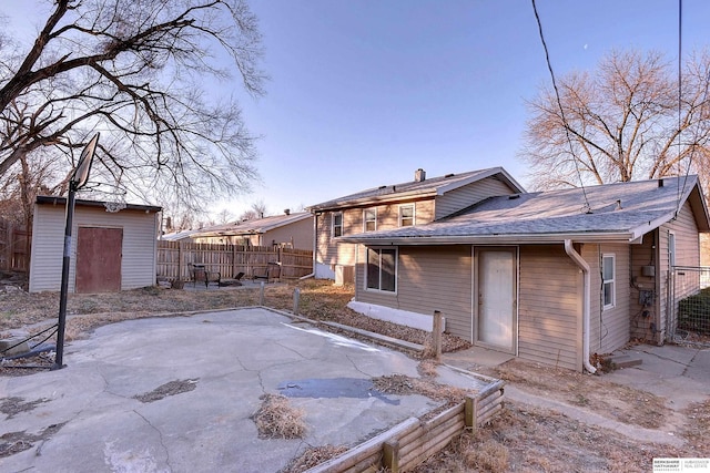 back of house with a patio area and a storage unit