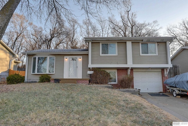 tri-level home with a garage and a front yard