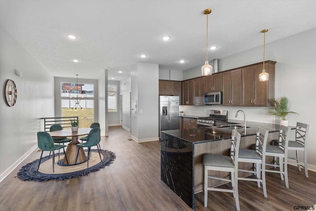 kitchen featuring sink, pendant lighting, dark hardwood / wood-style floors, and appliances with stainless steel finishes