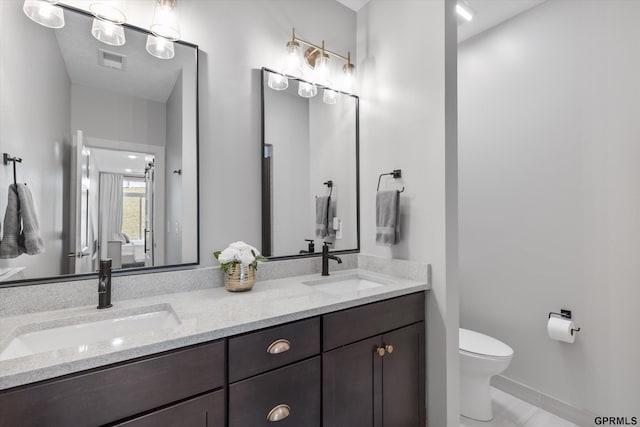 bathroom with tile patterned flooring, vanity, and toilet