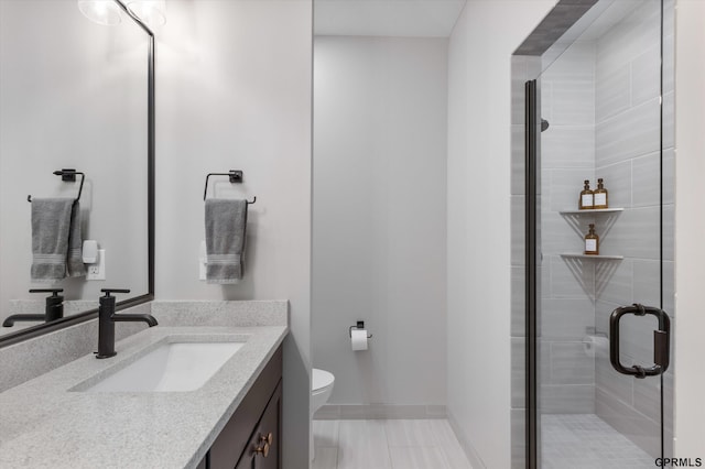 bathroom featuring vanity, toilet, and a shower with shower door