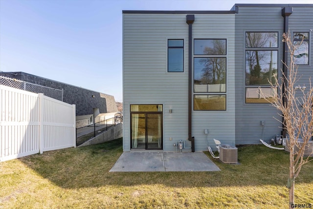 rear view of house featuring cooling unit, a yard, and a patio