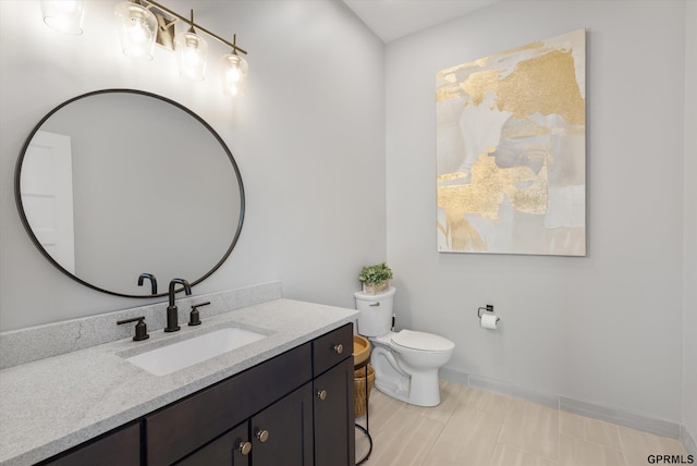 bathroom with vanity, toilet, and baseboards