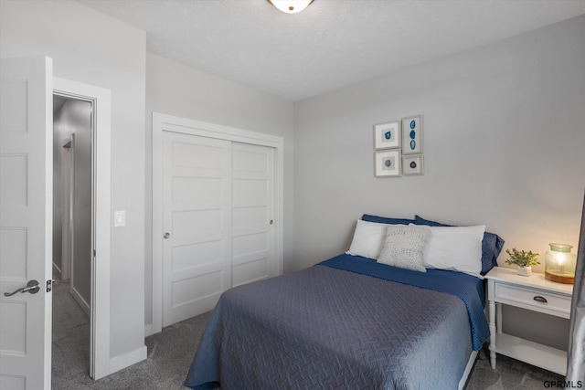 bedroom with a textured ceiling, a closet, carpet flooring, and baseboards