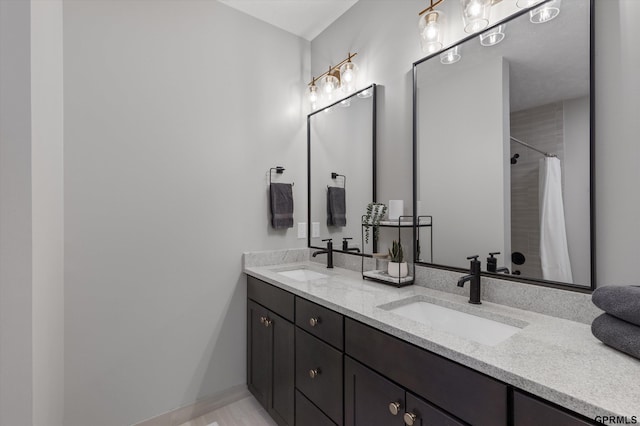 bathroom featuring double vanity, a shower with curtain, and a sink