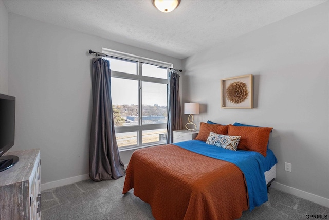 bedroom featuring carpet flooring, a textured ceiling, and baseboards