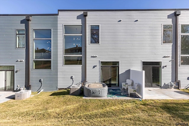 rear view of house featuring a patio area, cooling unit, and a yard