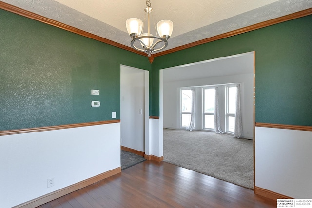 empty room with hardwood / wood-style floors, a textured ceiling, and a notable chandelier