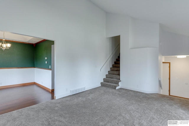 unfurnished room with wood-type flooring, high vaulted ceiling, and a chandelier