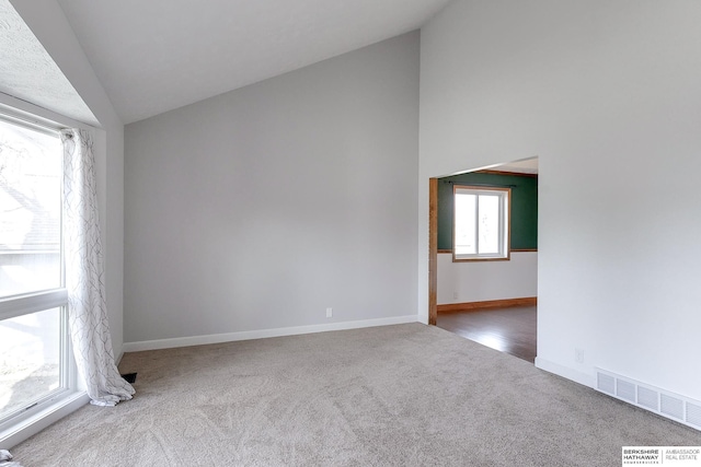 spare room featuring carpet and vaulted ceiling