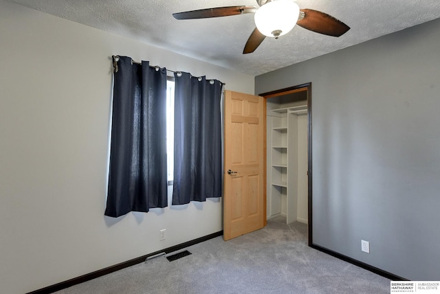 unfurnished bedroom featuring ceiling fan, multiple windows, a textured ceiling, and a closet