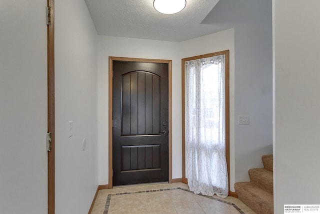 tiled entrance foyer with a textured ceiling