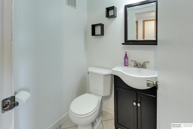 bathroom with toilet, vanity, and tile patterned floors