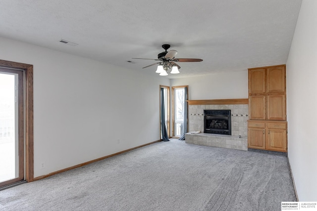 unfurnished living room with light carpet, plenty of natural light, and a textured ceiling