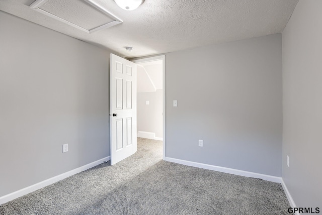 empty room with a textured ceiling and carpet floors