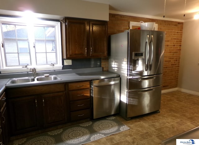 kitchen featuring sink, brick wall, and appliances with stainless steel finishes