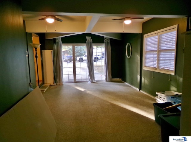 unfurnished room featuring carpet, ceiling fan, and beamed ceiling