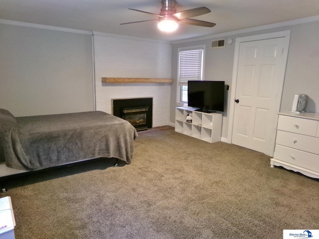 carpeted bedroom with a fireplace, ceiling fan, and crown molding