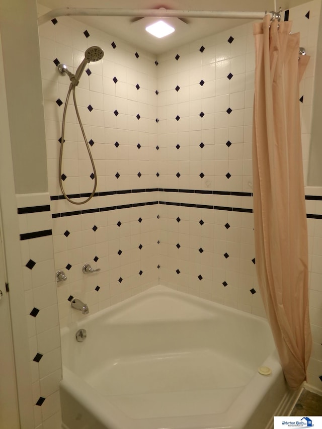 bathroom with shower / bath combo with shower curtain