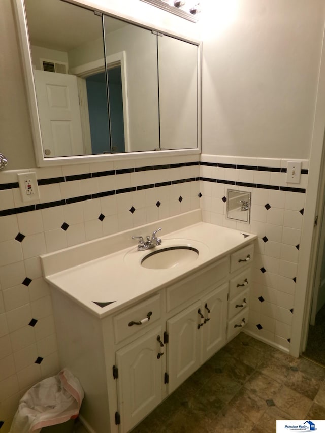 bathroom with vanity and tile walls