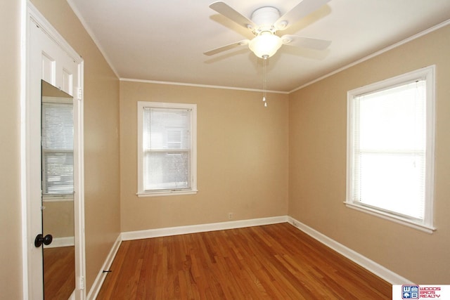 empty room featuring wood-type flooring, ceiling fan, and ornamental molding