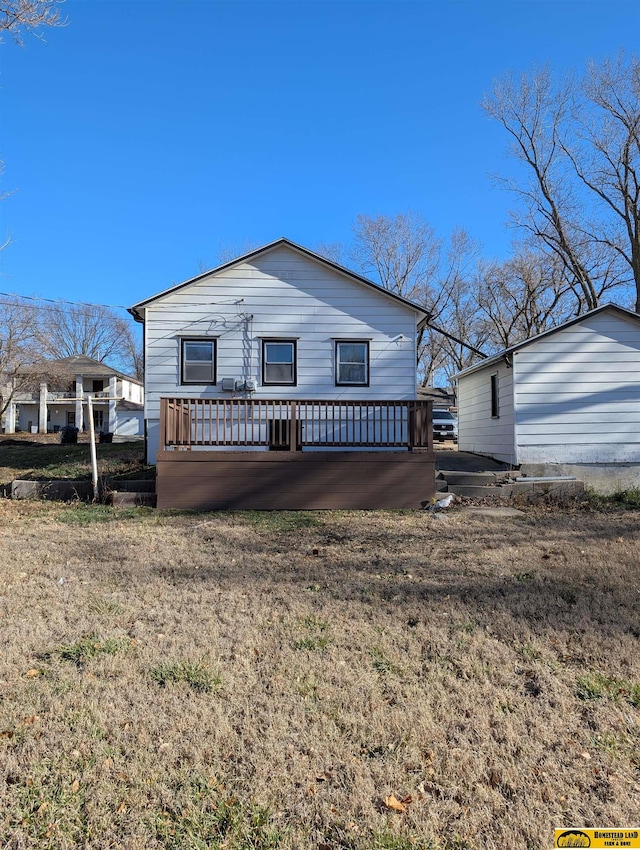 view of front of house with a deck and a front lawn