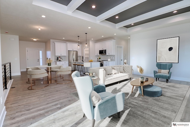 living room featuring beam ceiling and light hardwood / wood-style flooring