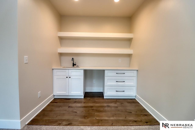 unfurnished office with dark hardwood / wood-style flooring and sink