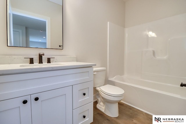 full bathroom featuring vanity, toilet, wood-type flooring, and bathing tub / shower combination