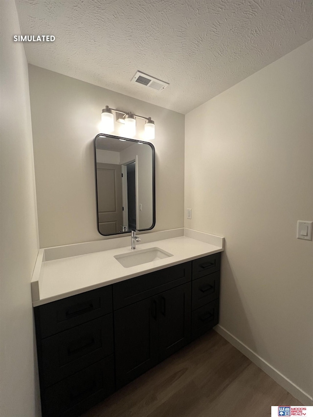 bathroom featuring vanity, hardwood / wood-style floors, and a textured ceiling