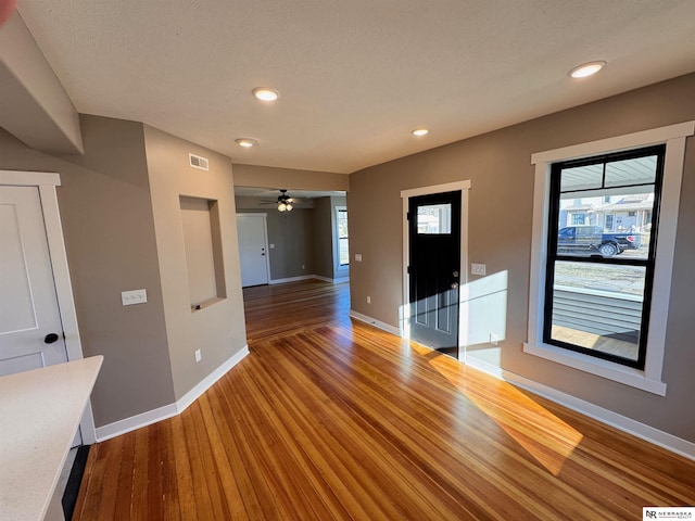 unfurnished living room with hardwood / wood-style flooring, ceiling fan, and a wealth of natural light