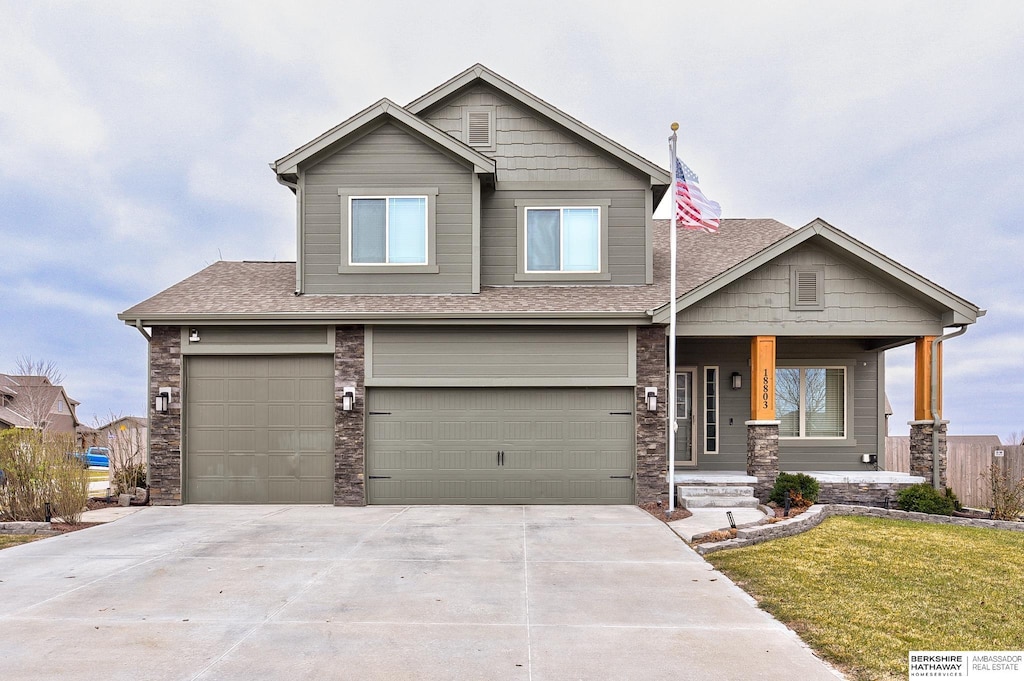 craftsman-style house with a garage and a front lawn