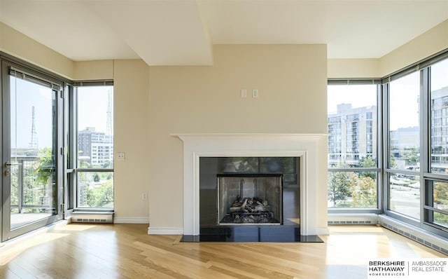 unfurnished living room with light hardwood / wood-style flooring and a wealth of natural light