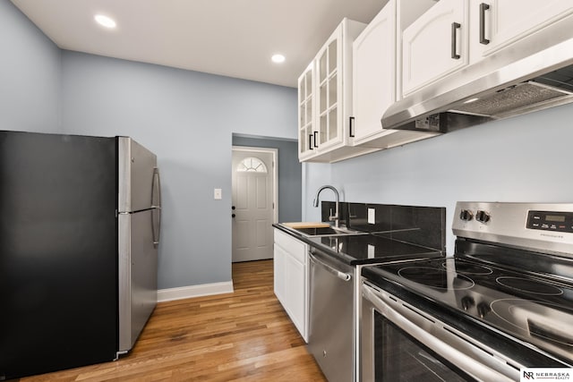 kitchen with white cabinetry, sink, light hardwood / wood-style flooring, and appliances with stainless steel finishes