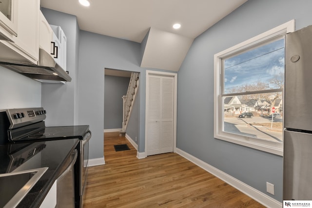 kitchen with white cabinets, stainless steel appliances, and light hardwood / wood-style floors