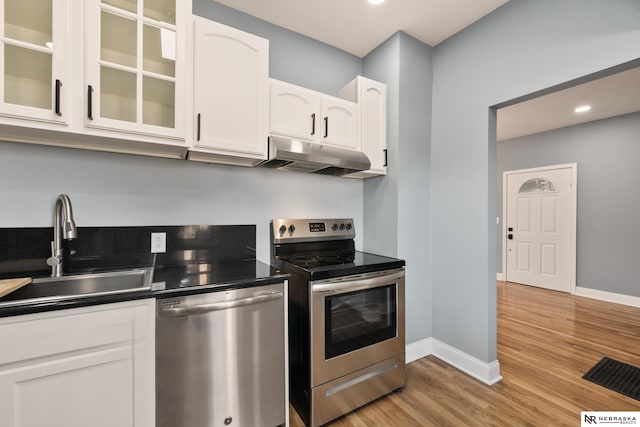 kitchen featuring white cabinets, sink, appliances with stainless steel finishes, and light hardwood / wood-style flooring