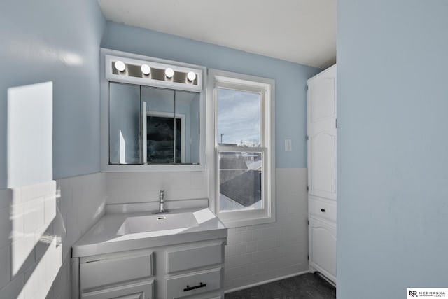 bathroom featuring vanity and tile walls