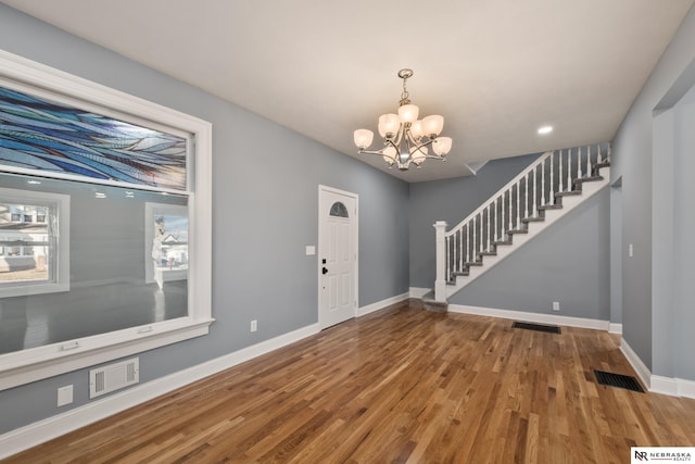 entrance foyer featuring hardwood / wood-style flooring, plenty of natural light, and an inviting chandelier