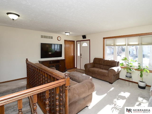 carpeted living room featuring a textured ceiling