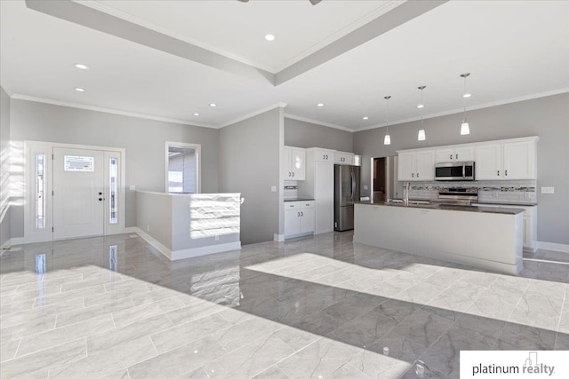 kitchen featuring a center island with sink, sink, hanging light fixtures, white cabinetry, and stainless steel appliances