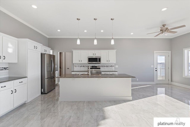 kitchen with tasteful backsplash, pendant lighting, stainless steel appliances, and a kitchen island with sink